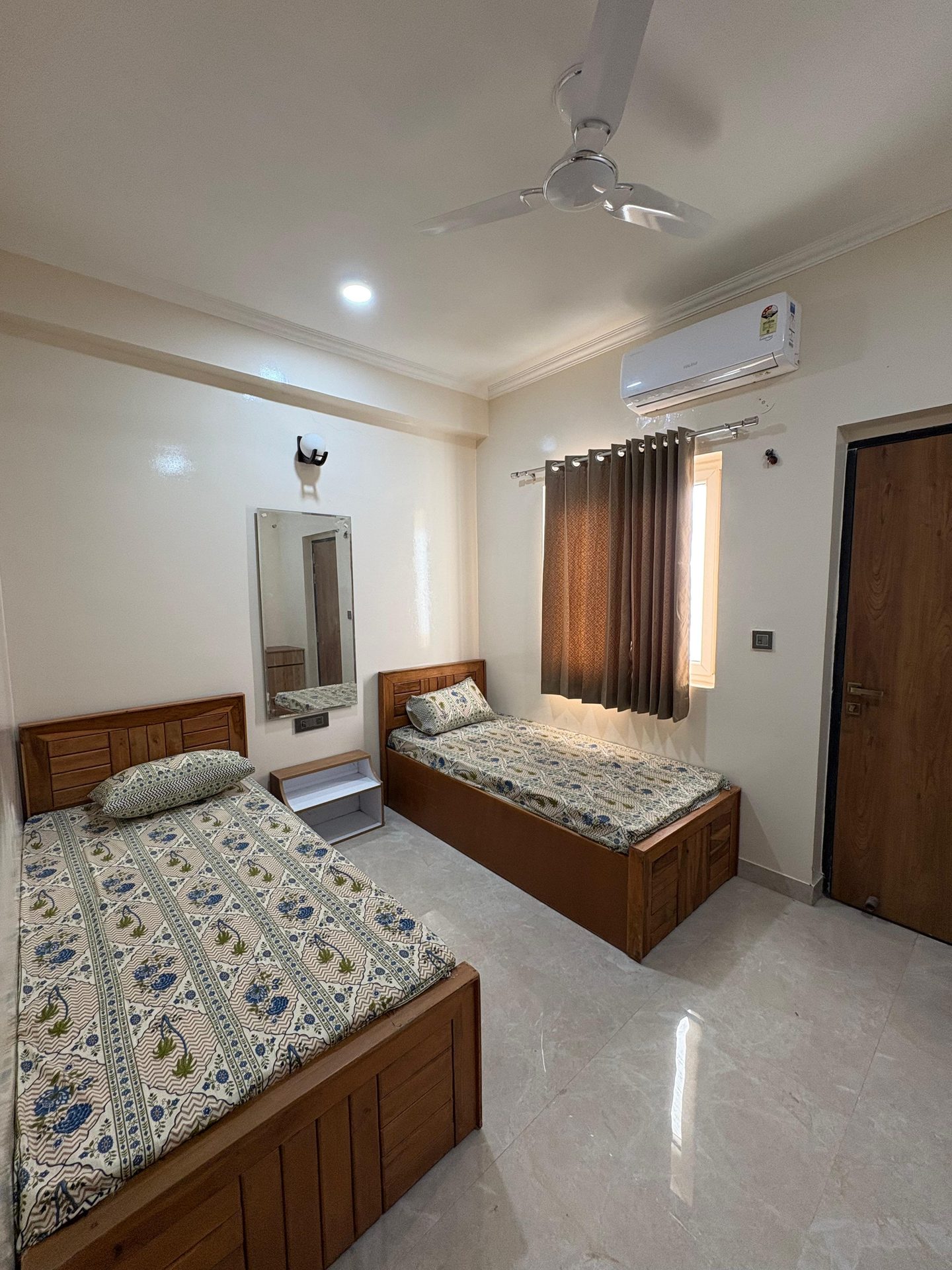 A twin-sharing room with two single beds, air-conditioning and natural light